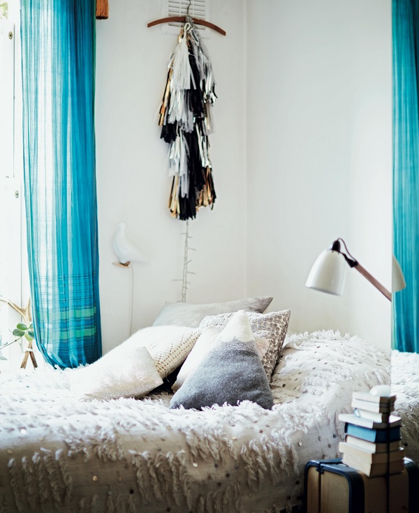 In the small bedroom, every inch of space is put to good use. The windowsill is lined with small plants and gilt frames (above) and a very tight nook at the foot of the bed gets a wooden side table for dishes of jewellery and vases of flowers, with a dressmaker’s bust adding character and doubling as necklace storage (below). To make up for the lack of built-in storage, Stephanie collects vintage suitcases and stacks them along the wall to hold items that she doesn’t need to access frequently, such as off-season clothes (also below).