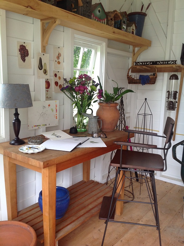 The interior is unfinished, featuring an unpainted cedar floor and one bracketed shelf where Mintun has her collection of birdhouses.
