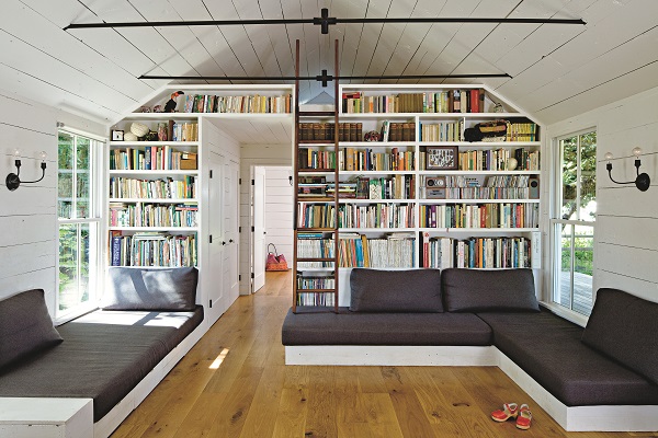 The parents’ bedroom is located on the mezzanine level of the main room, which is lined with vintage Moroccan Beni Ourain rugs and accessed via a walnut ladder. In addition to a separate kids’ bedroom, the built-in sofas double up as beds for guests.