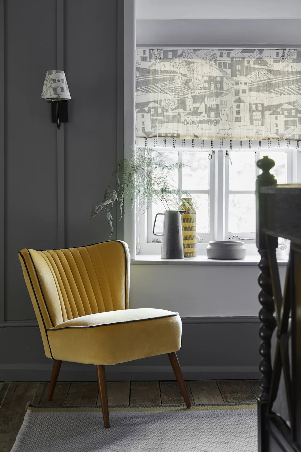 SWEDISH BLIND: By the Sea Scree, Charcoal SEA-67-38 £52/mtr lined in Simple Ticking Detail Charcoal TICKING-38 £49.50/mtr; LAMPSHADE: By the Sea Scree, Charcoal SEA-67-38 £52/mtr; RETRO CHAIR: Honey Velvet VELVET-72 £58/mtr piped in Thunder Velvet VELVET-74 £58/mtr; RUG: Geometric Grey, Saffron, Winter RGEO-95-52-50 £240