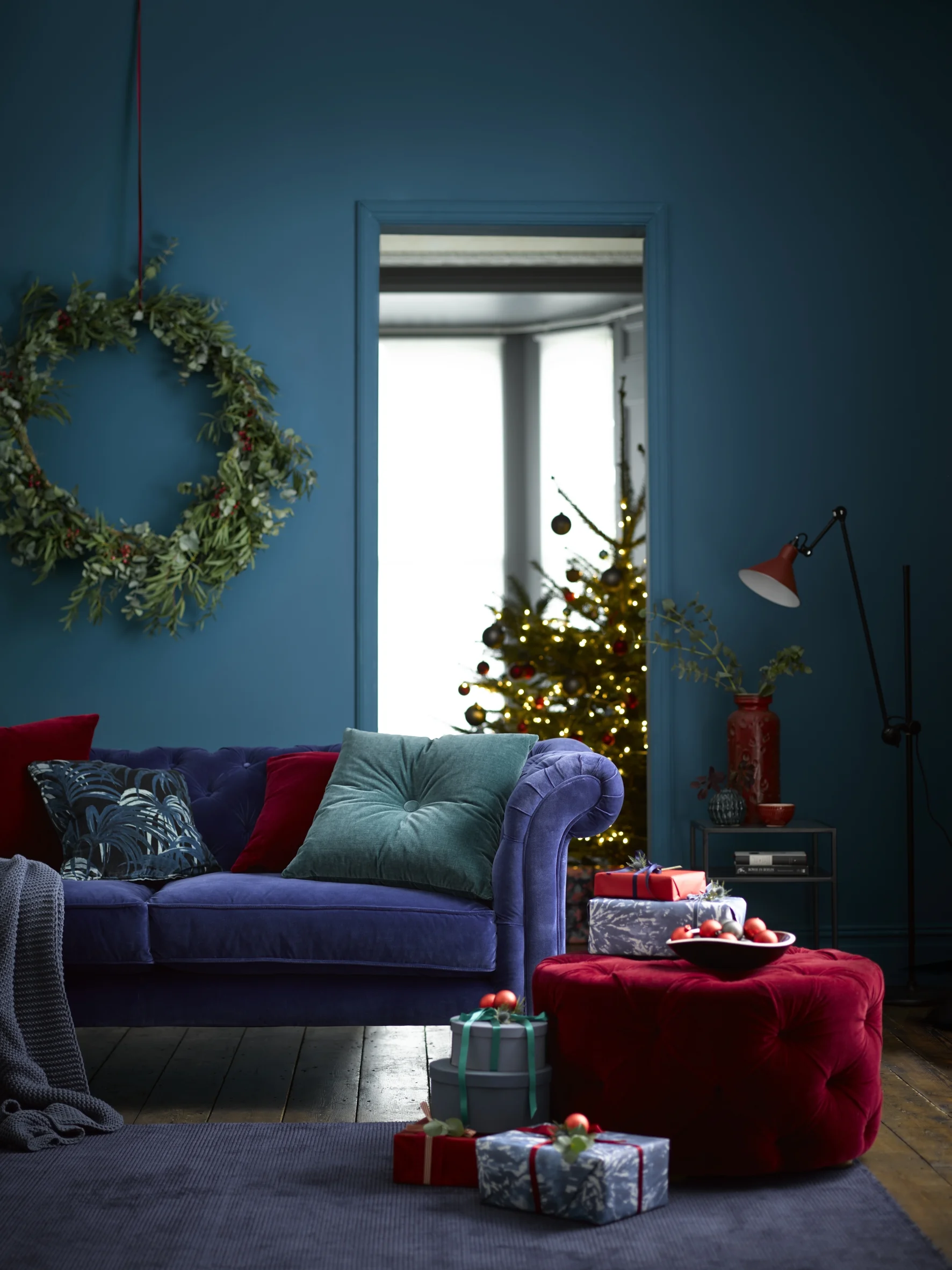 Oscar three seat sofa in Prussian Blue pure cotton matt velvet £2,590, Georgette footstool in Claret pure cotton matt velvet £710 and Wisley cushion in Lake velvet £50.