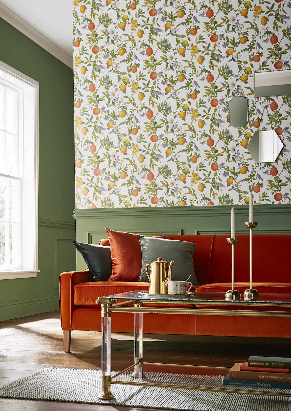 Don Large Sofa - Shown here in Downton Marigold Luxury Velvet. This rather refined sofa plays nicely with all sorts of décor. Its design is simplicity itself, with a fixed upholstered back rather than cushions and wooden legs rather than a base frame. Just add a cat, a dog or some kids and you’ll feel right at home. Amalfi Fresco wallpaper from Graham and Brown.