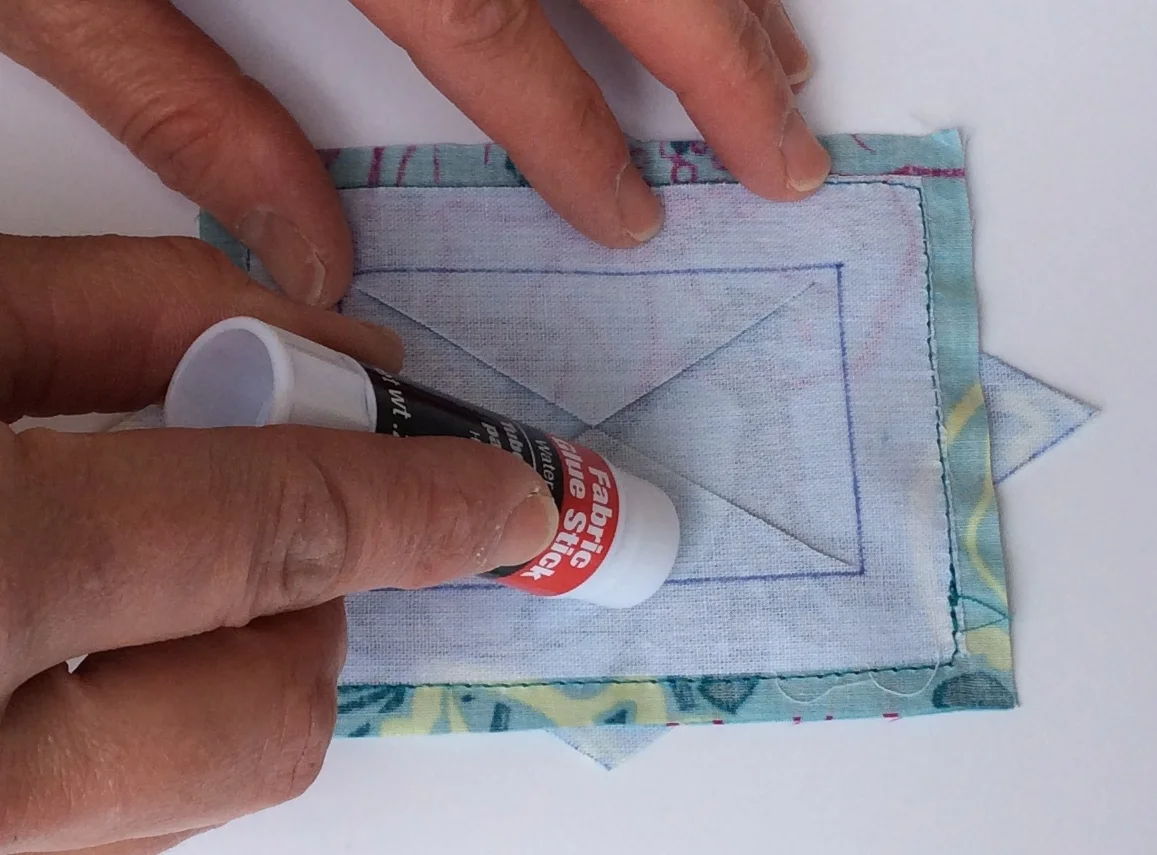 I put the glue at the base of the triangle near the fold line.