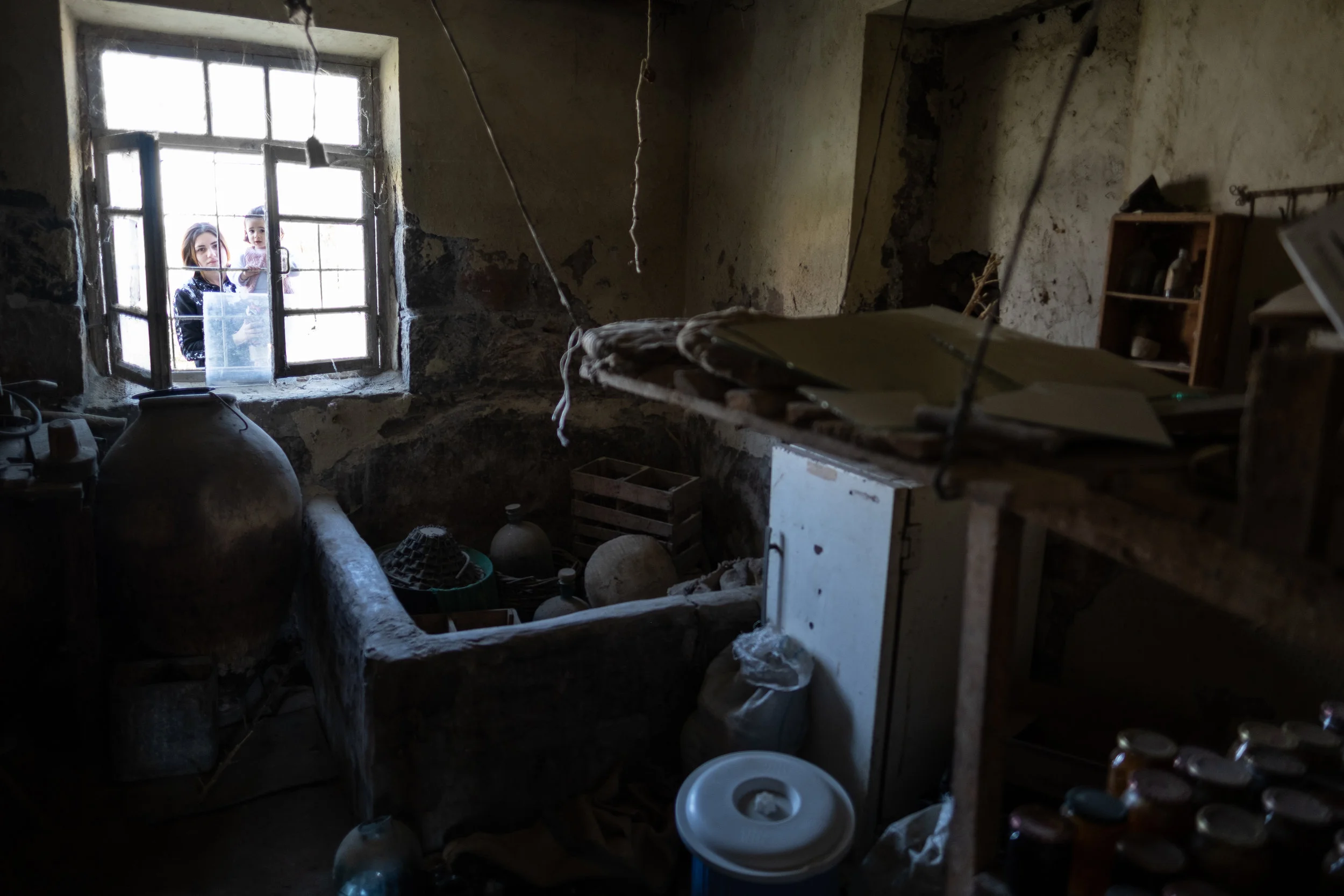Svetlana’s daughter in-law and granddaughter looking inside their homes cellar.