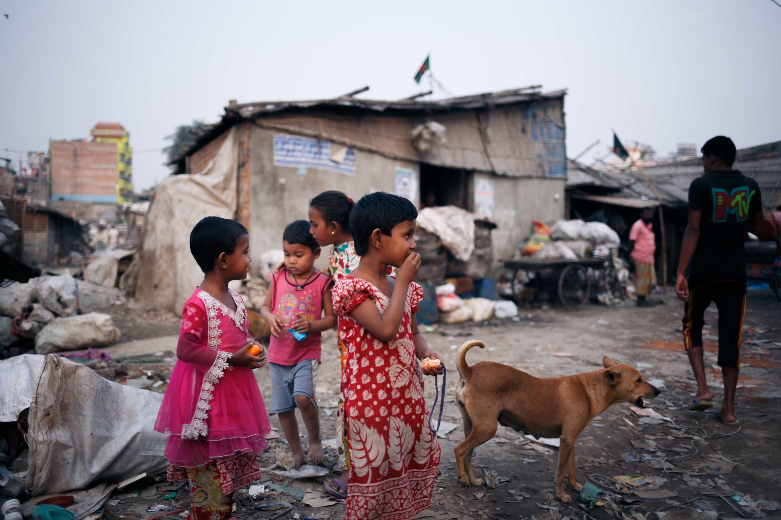  Local children watch as dogs squabble over parts of animal carcasses left behind. 