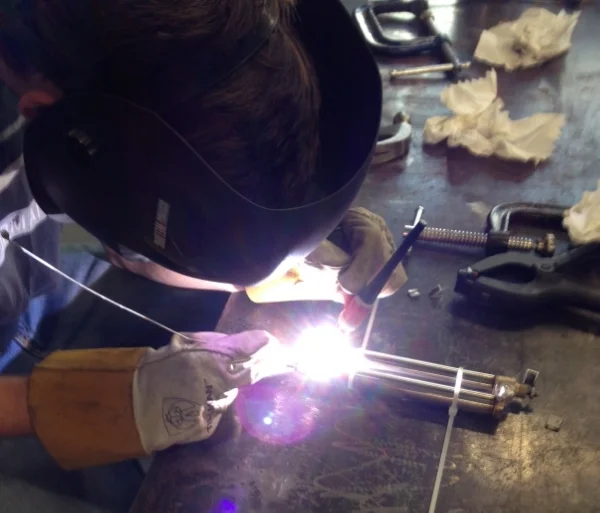 Alex in the OU machine shop welding the cylinders together!