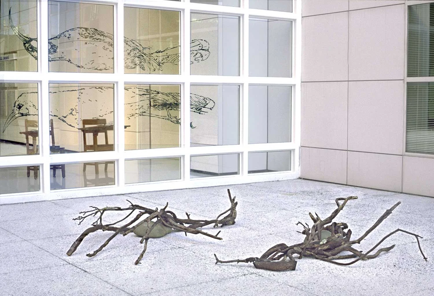 Huia: A Story of Extinction, an installation by Lorna Stevens combining a book, sound recording, chairs, painted elements, stone, and sticks to tell the story of the extinct huia bird.