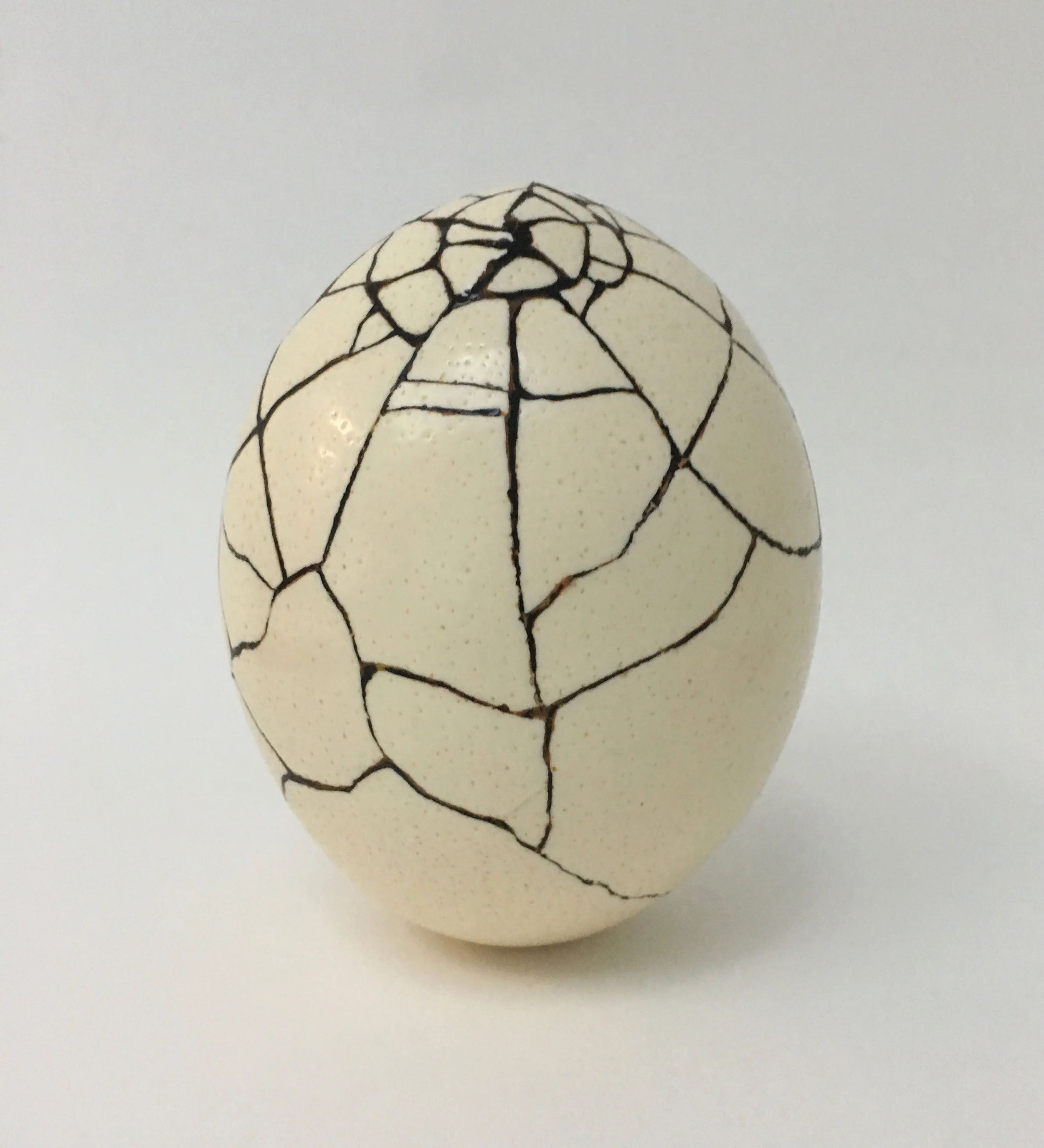 Repair, an artwork by Lorna Stevens made from a broken ostrich egg mended with lacquer and sand using the Japanese tradition of kintsugi, which honors breakage and repair as part of an object’s history.
