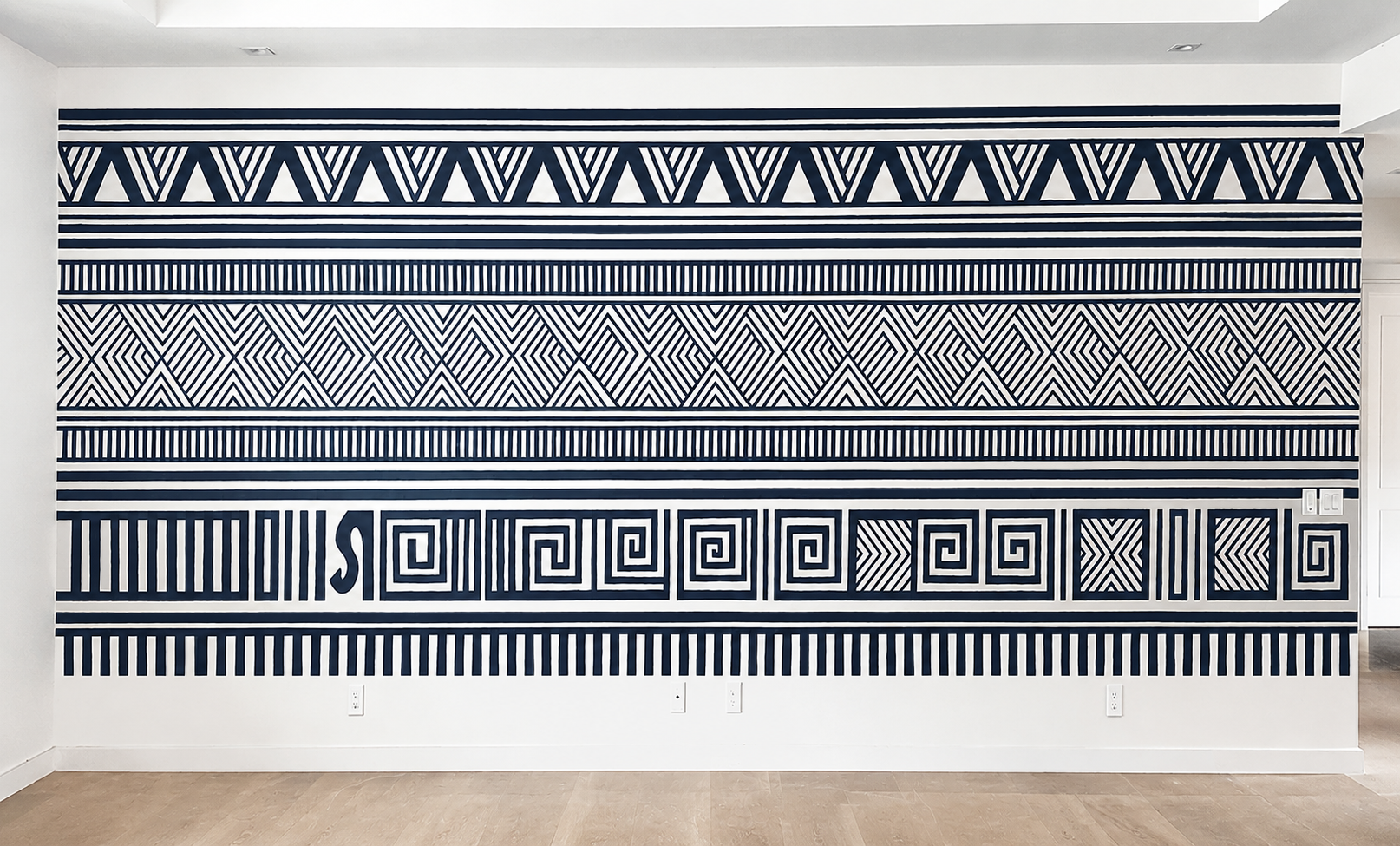 Hawaii House Tattoo, a large wall mural by Lorna Stevens composed of horizontal bands of dark blue geometric patterns inspired by traditional Hawaiian tattoo and kapa designs.