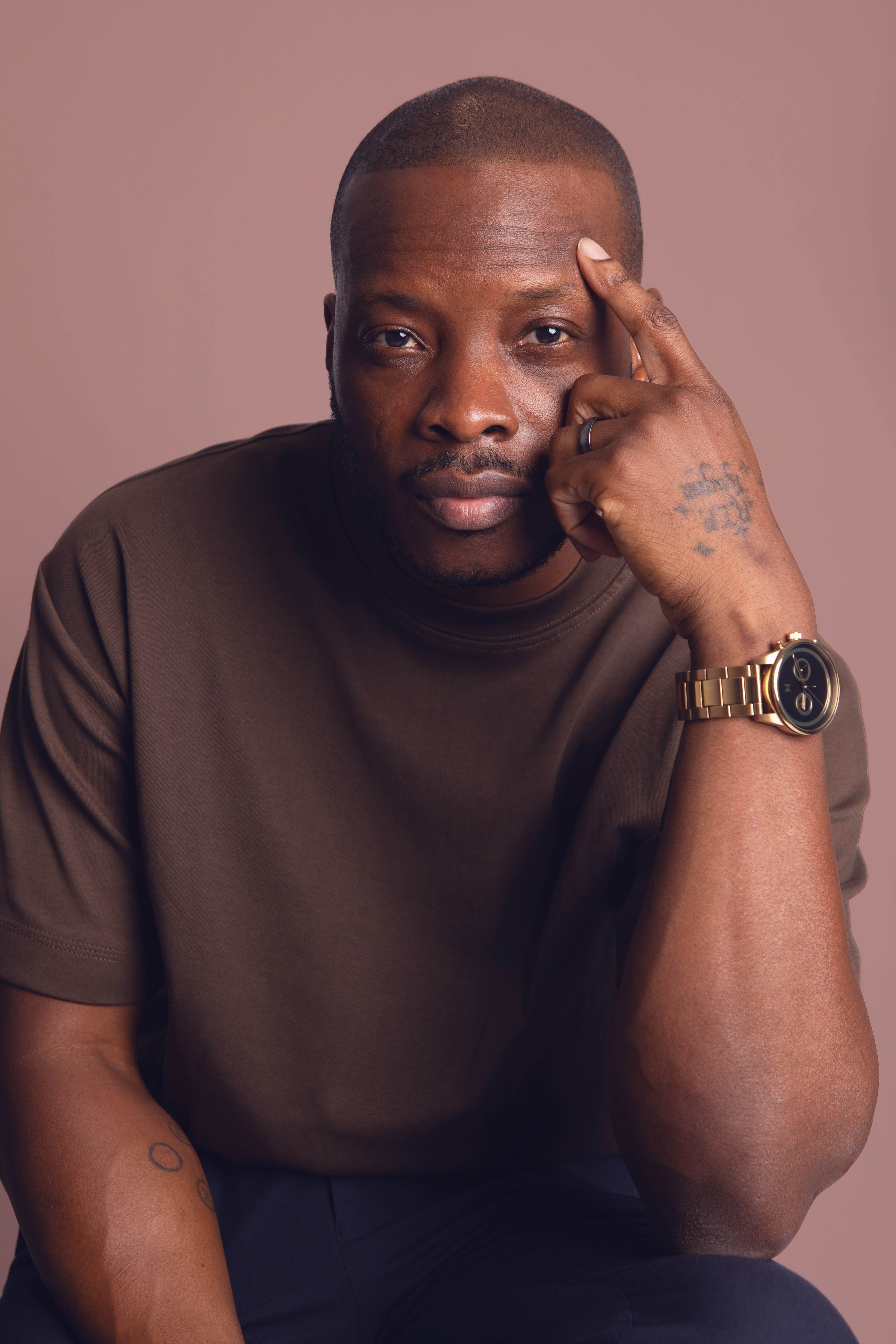 black man sitting in a chair with gold watch