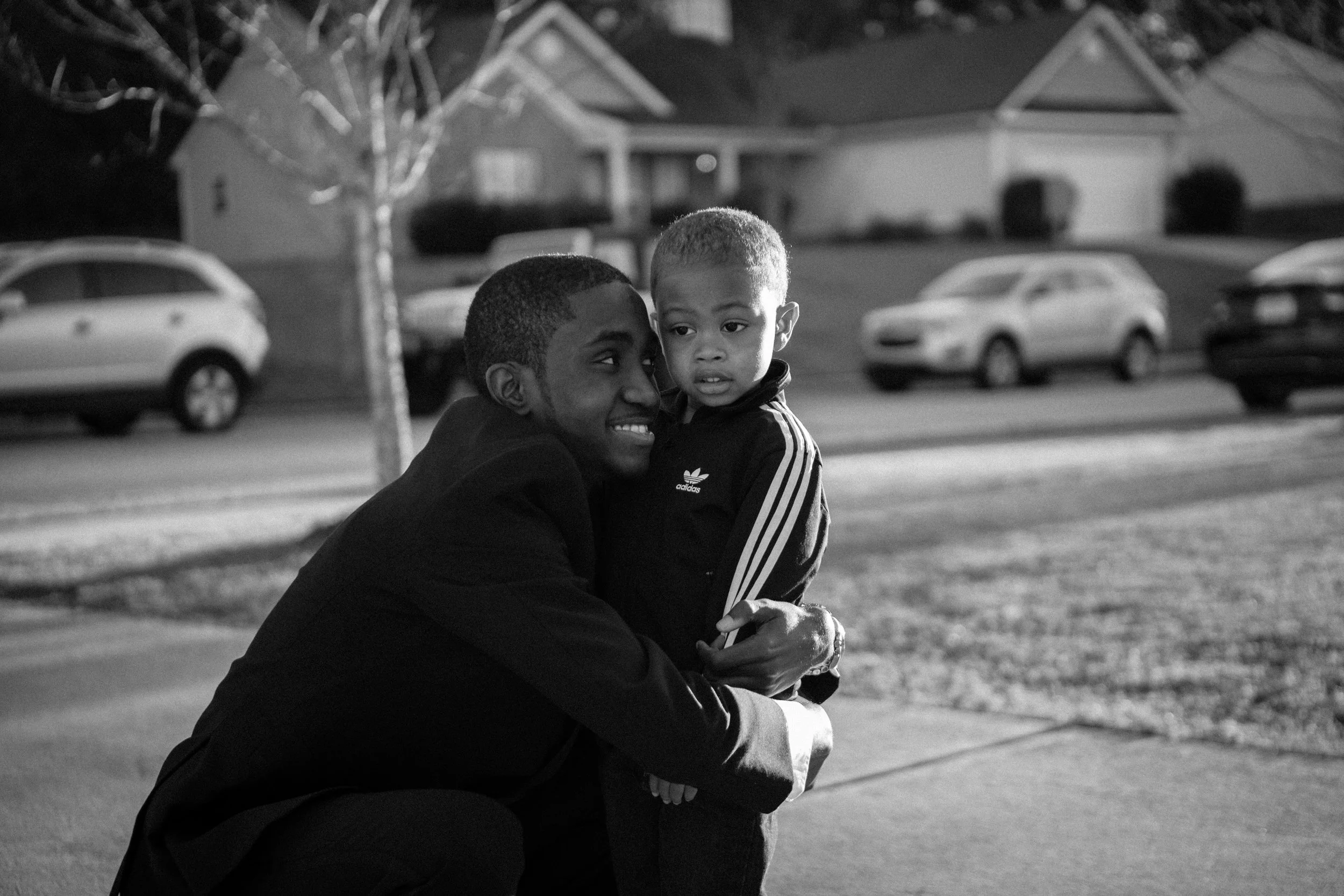Boy in a tux hugs a little boy