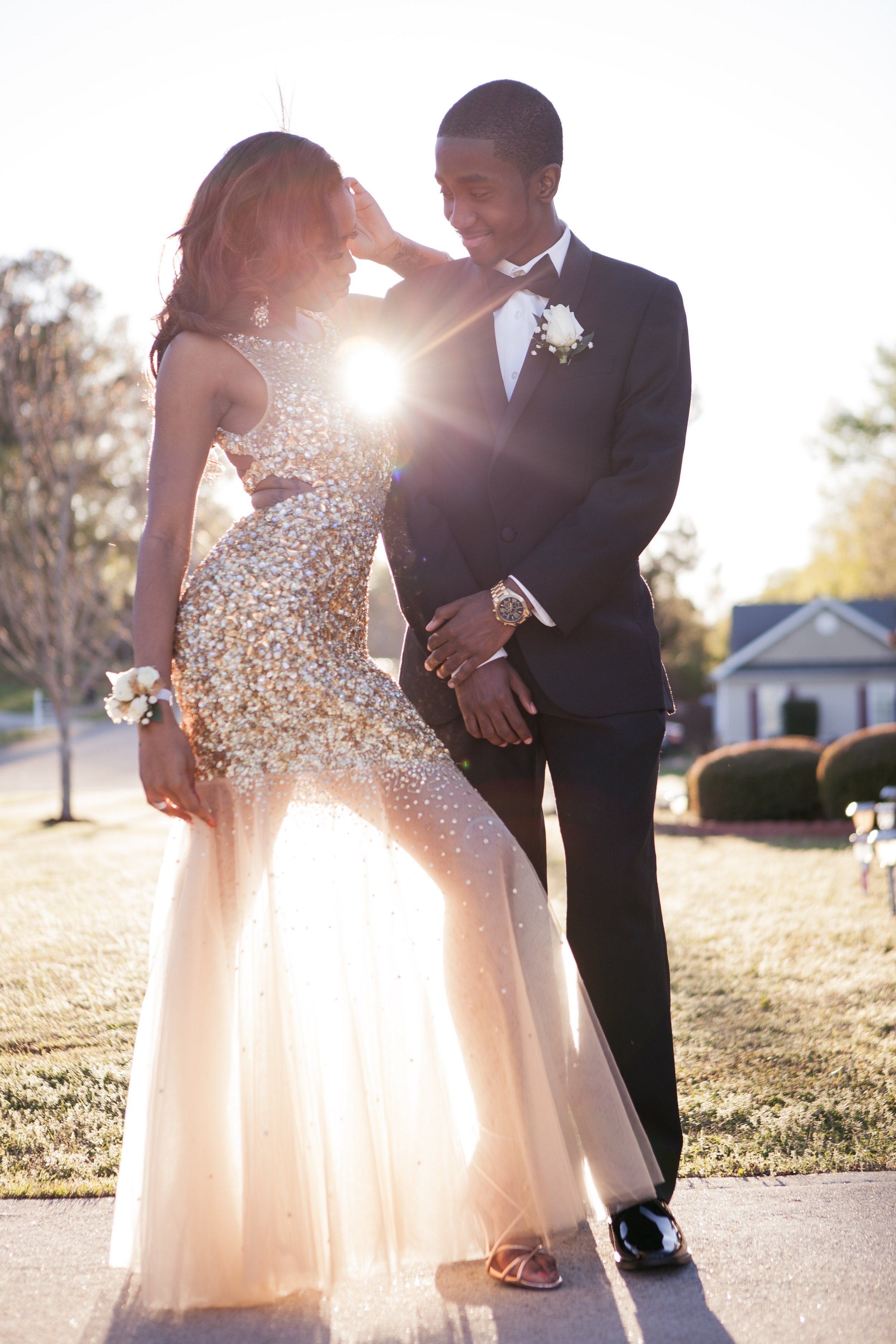 Boy and a girl in promo dressed liked they are going to prom standing in front of a sunset