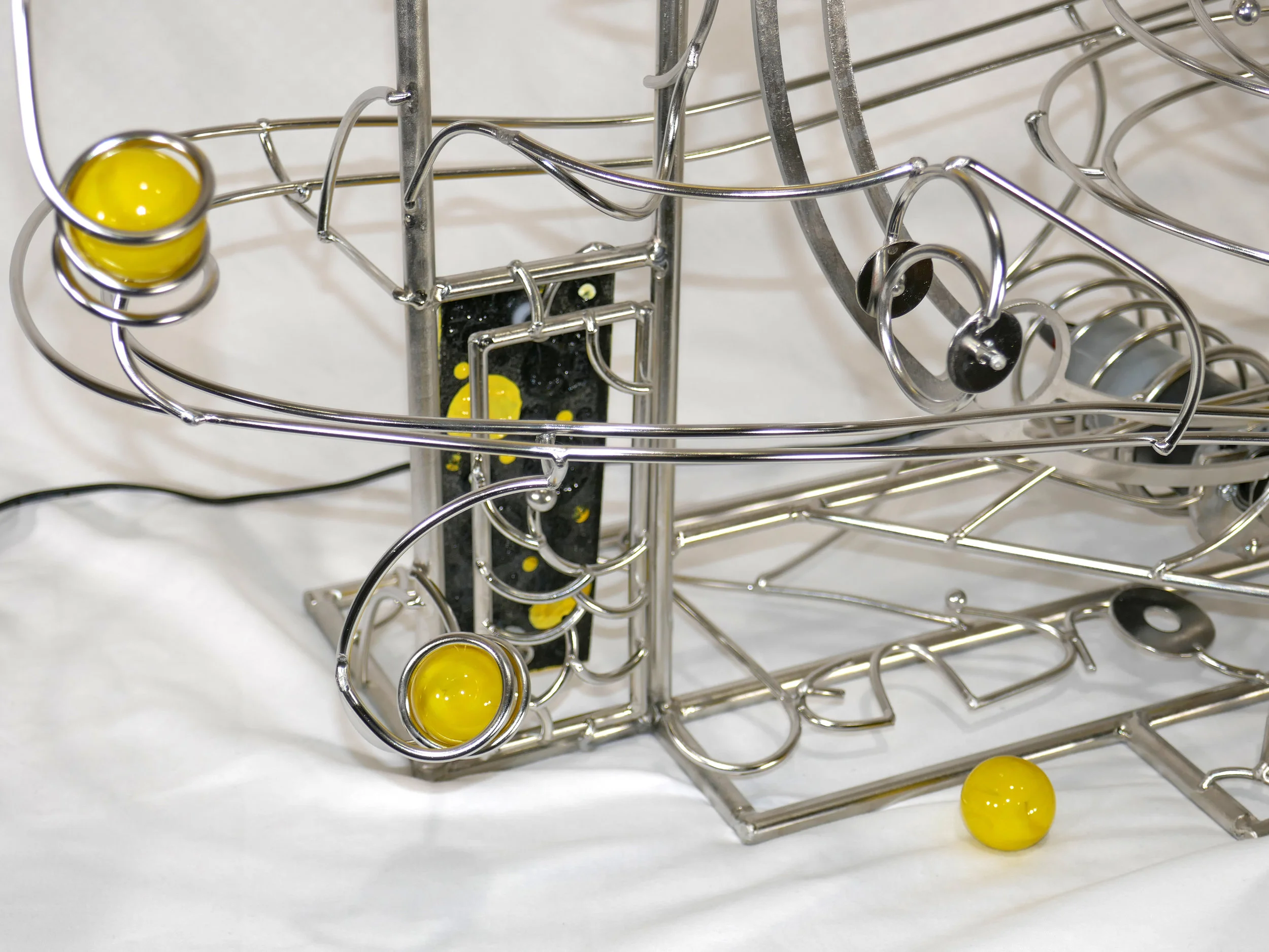 Rolling ball marble machine - close up of yellow marble detail