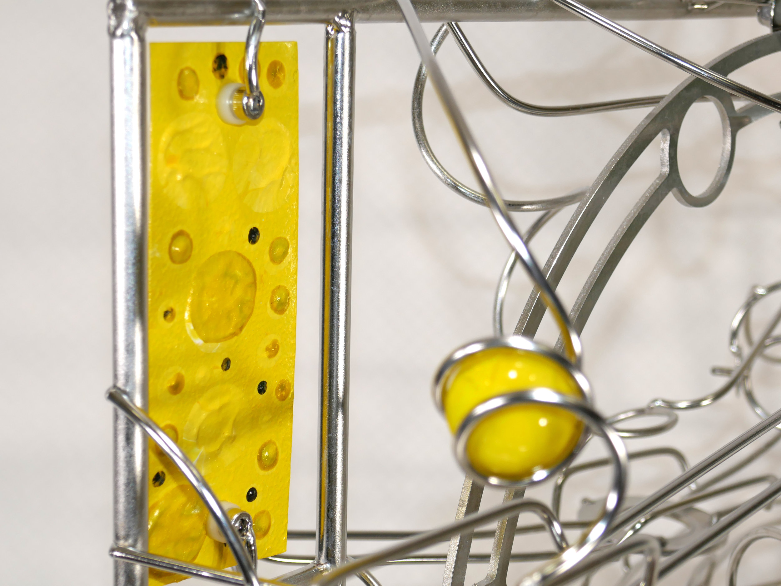 Rolling ball marble machine - close up of yellow marble detail