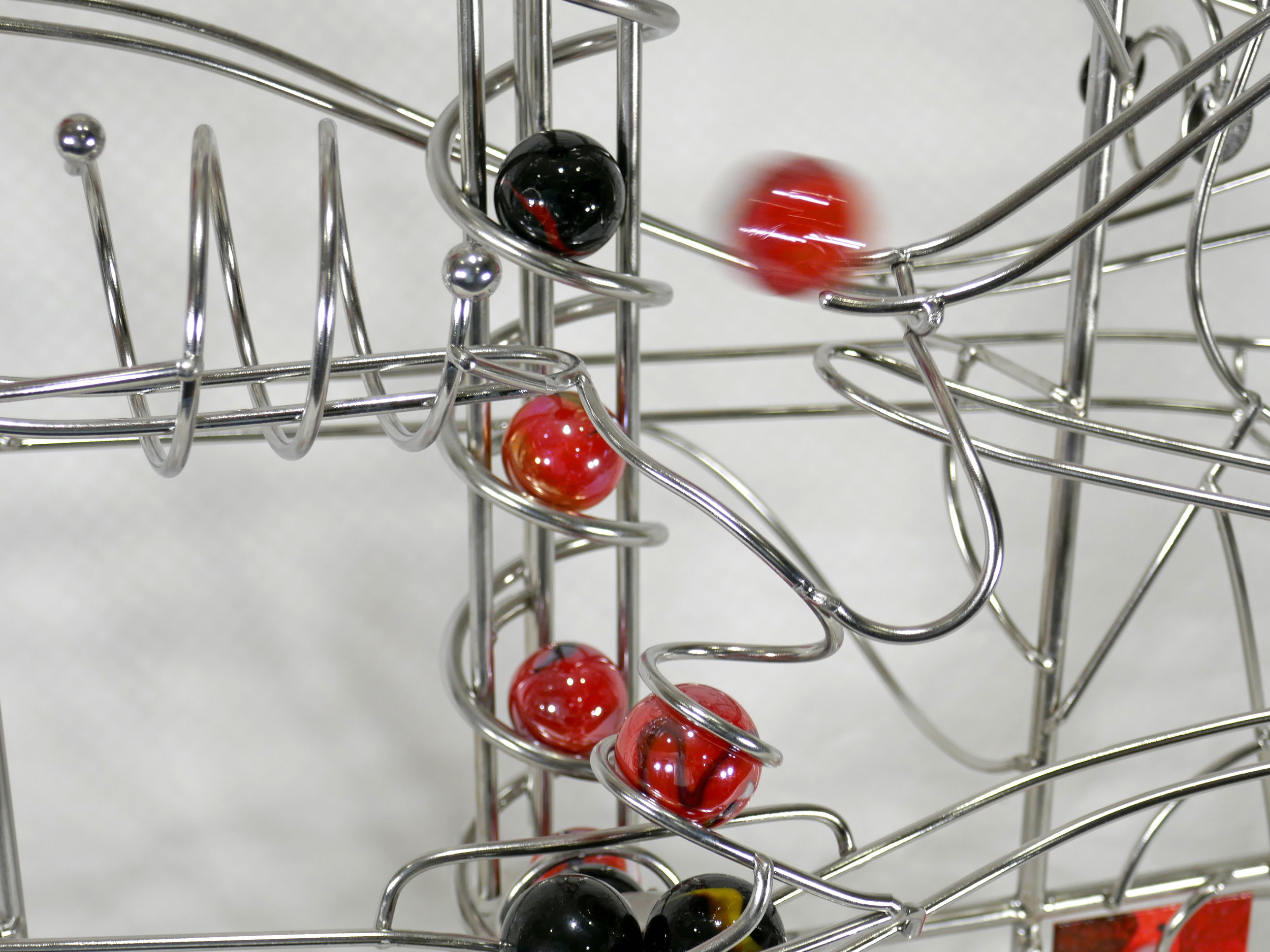 Rolling ball marble machines - action shot showing marbles travelling along the rails