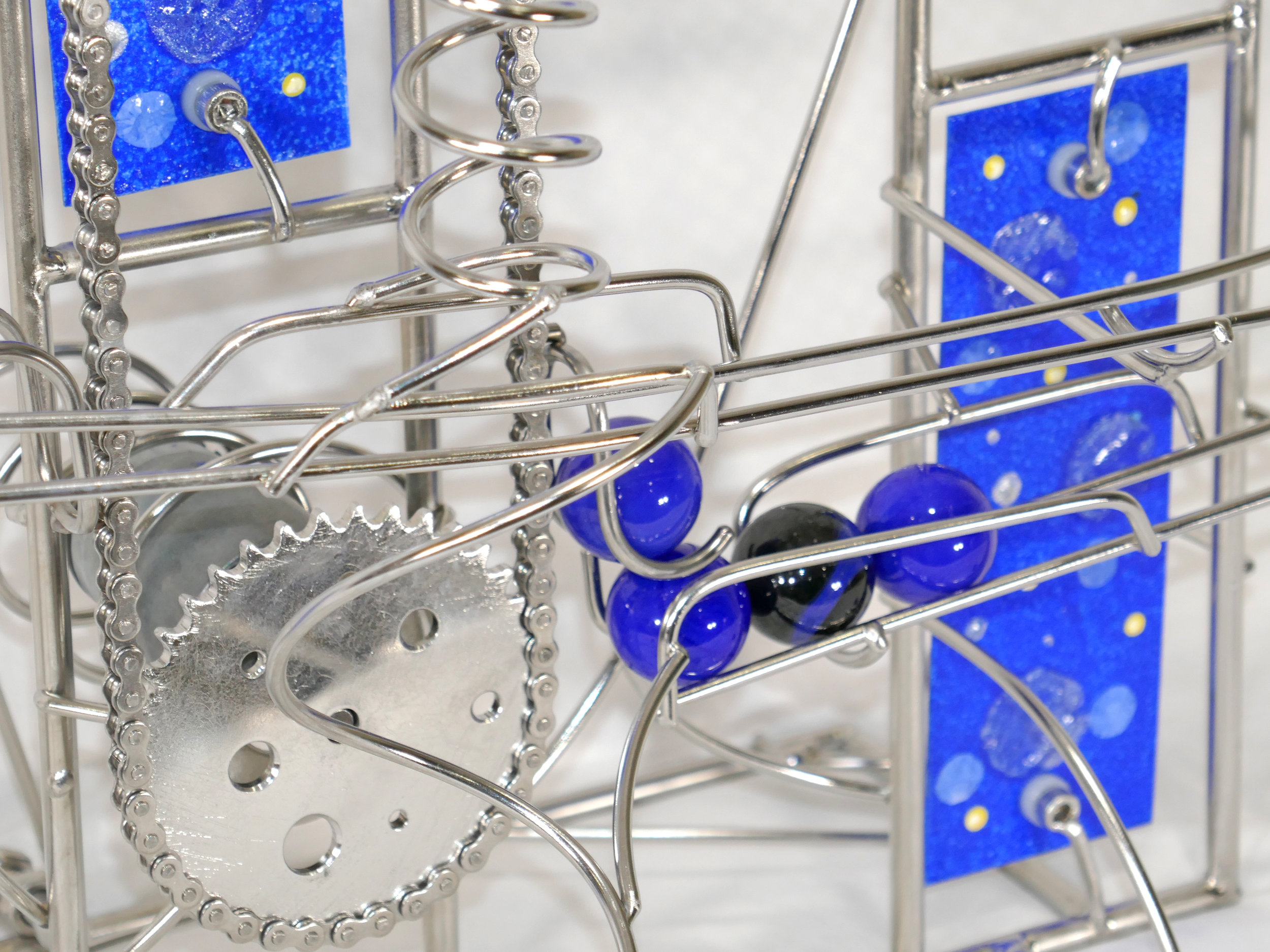 Rolling Ball Sculpture - kinetic art works - showing the blue marbles going up the chain lift