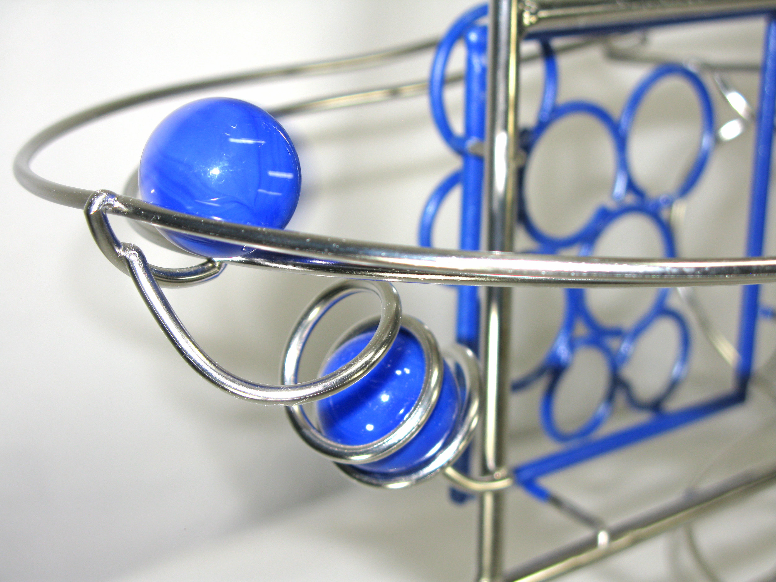 Rolling ball marble Sculpture - close up of blue corner detail with blue marble whizzing by