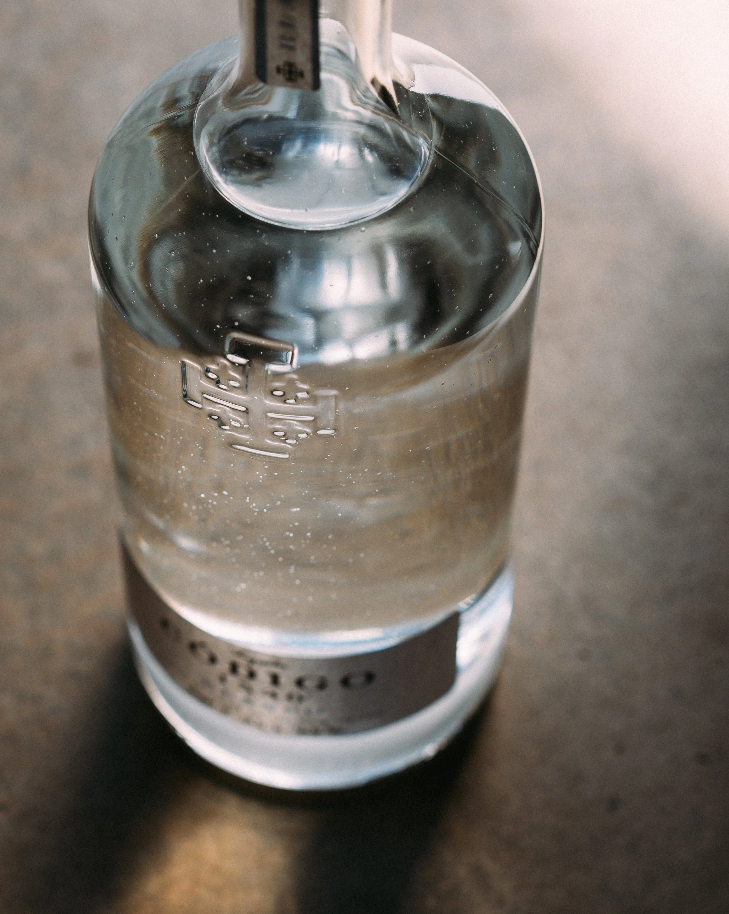 detail product photo of embossed logo on codigo tequila bottle