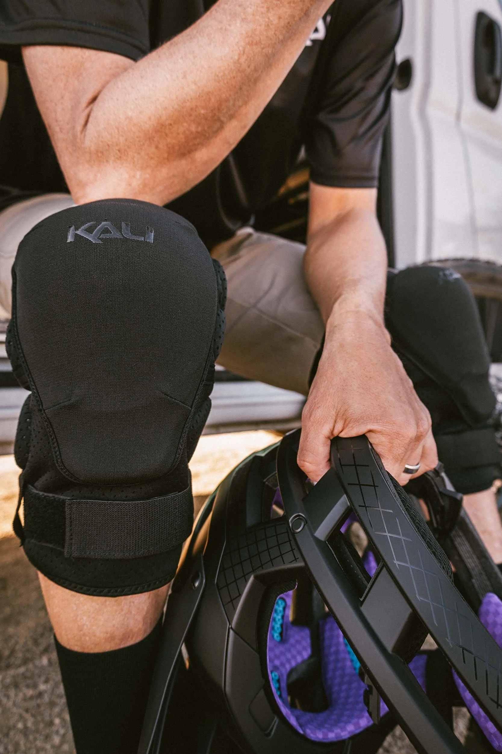 catalog photo of rider with helmet sitting at camper van