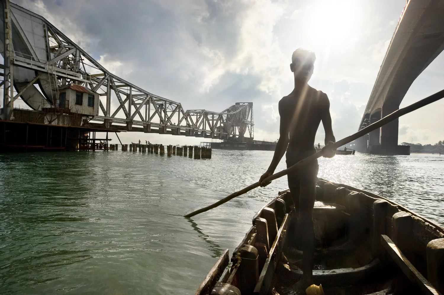 Against the backdrop of rail and road bridges leaving the mainland to the island of Rameswaram, a diver mans his boat out to search for sea treasures. While Rameswaram was once famed for its exceptional pearls, these divers now mainly search for souvenir shells and coins cast off the bridges by Hindu pilgrims who believe in the good luck this brings on their way to a holy land.