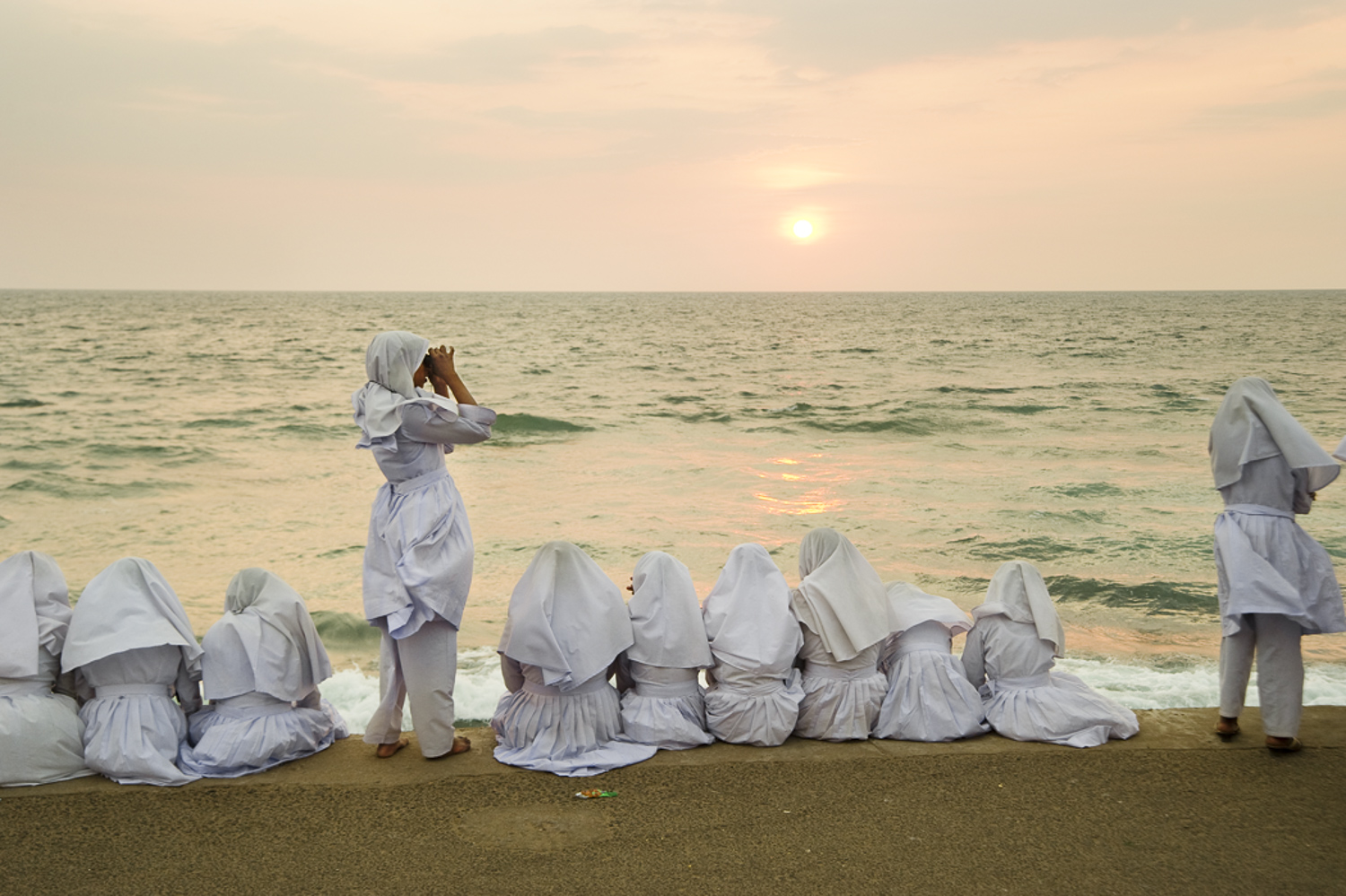  Schoolgirls in Colombo take in a sunset, looking across the Palk strait to India. 
