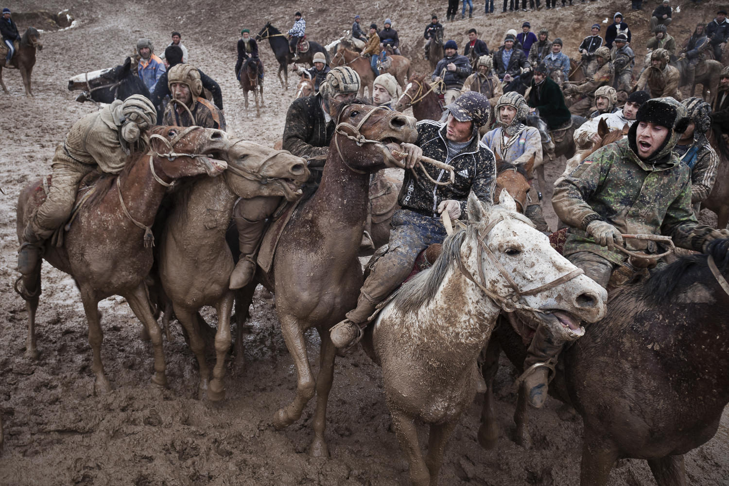  Buzkashi players fight for possession for the buz during a muddy match in Nojibolo, western Tajikistan. 