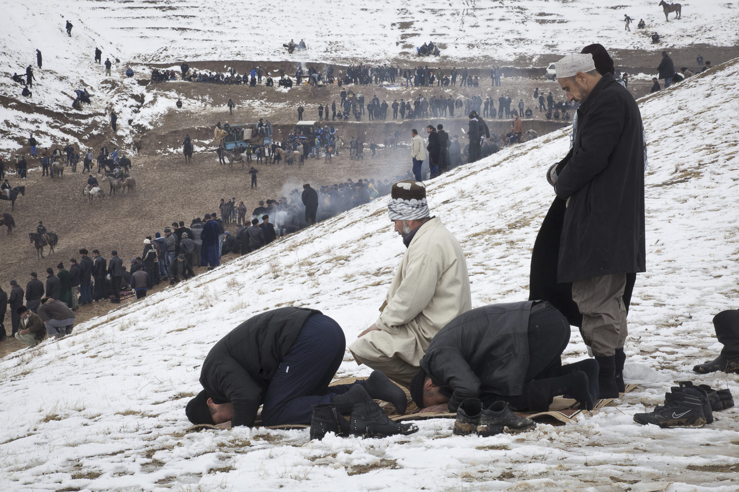  Using carpets won by the horseback riders, buzkashi fans near Hissor set aside time for afternoon prayers. 