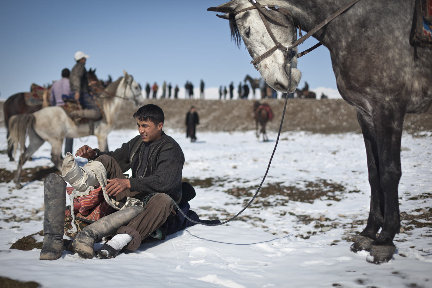  A player puts on his boots before a match near Dushanbe. 