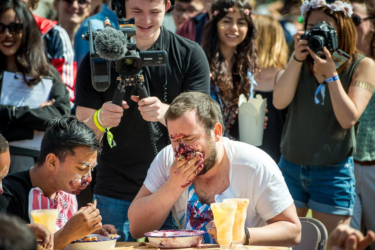Festival goers taking part in a pie-eating contest, Field Day, Victoria Park, London, UK, 06/06/2015 © Dosfotos