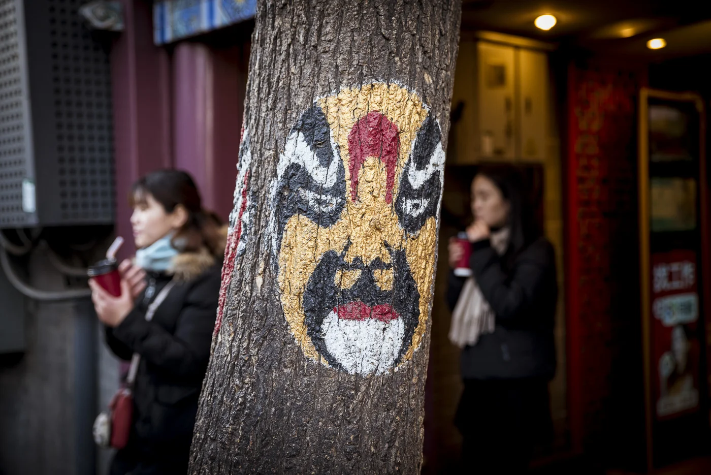 Chinese Opera mask painted on a tree in Nanluoguxiang Hutong, Dongcheng District, Beijing, China © Dosfotos