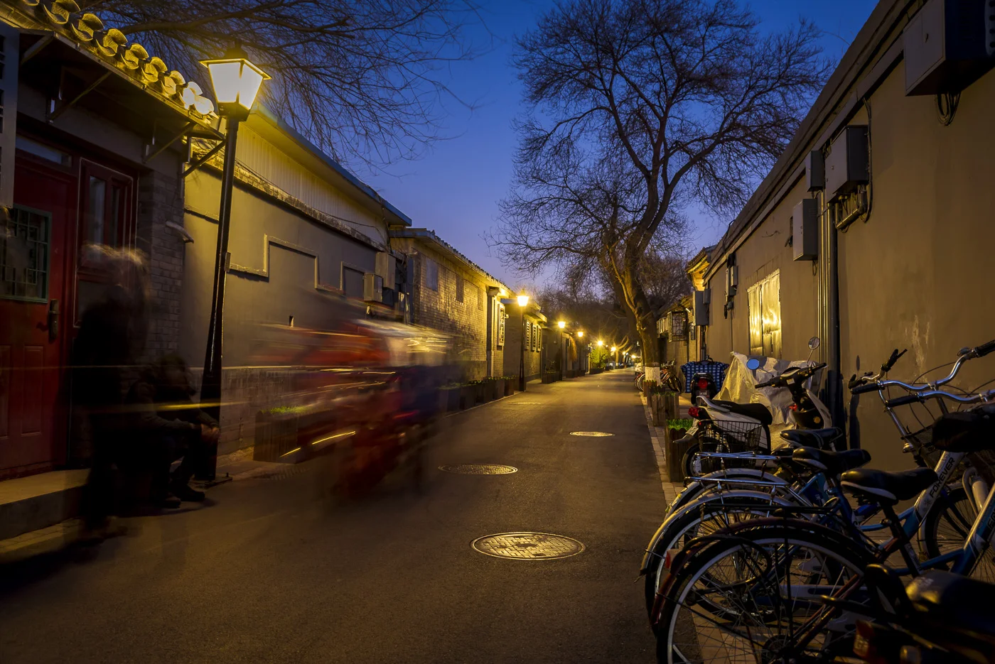 Motorbike driving through a Hutong at night, Beijing, China © Dosfotos