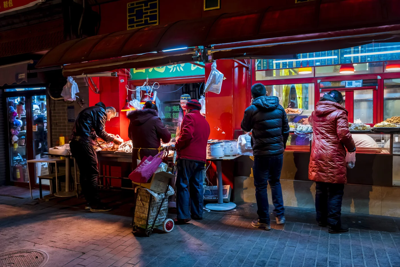 People buying food from a stall in Beijing, China © Dosfotos