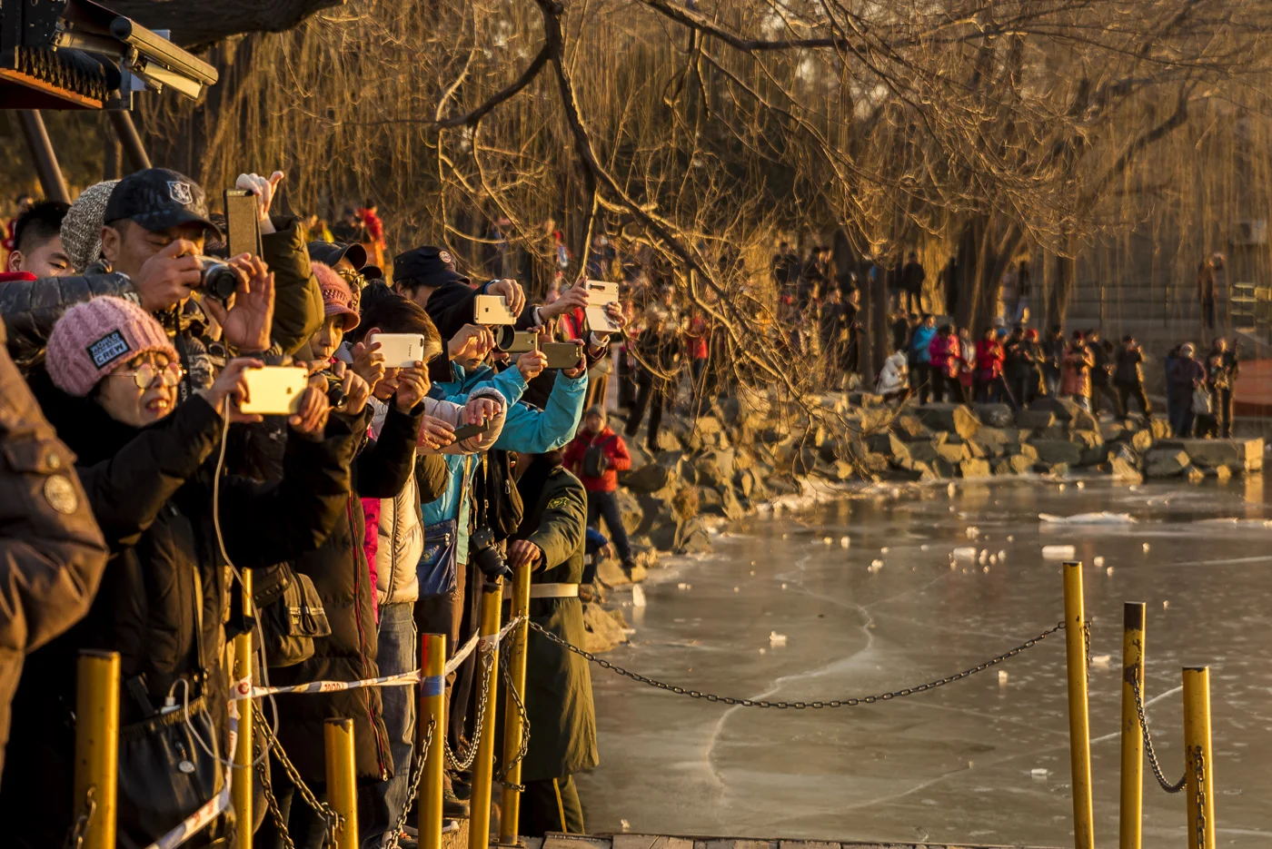 Crowd of tourists taking photographs of the 17 Arch Bridge at sunset, The Summer Palace, Beijing, China © Dosfotos