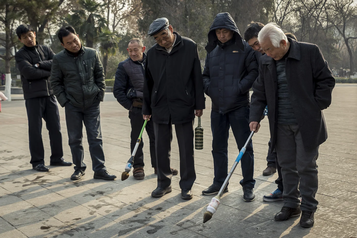 Chinese men practicing calligraphy in Revolution Park, Xian, China © Dosfotos