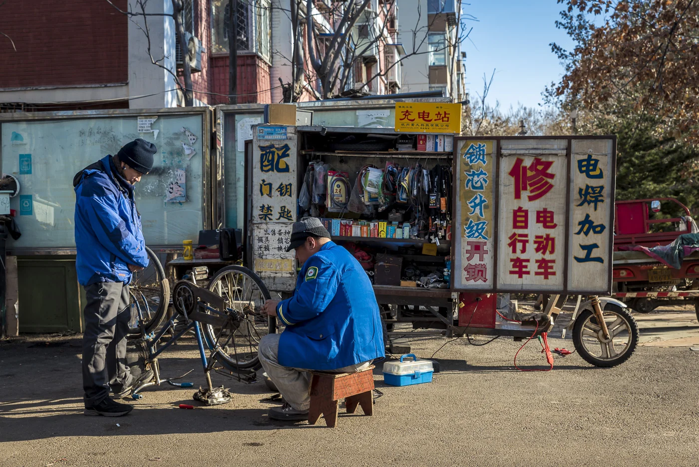 Bicycle repairs in a street in Dashanzi, Chaoyang District, Beijing, China © Dosfotos