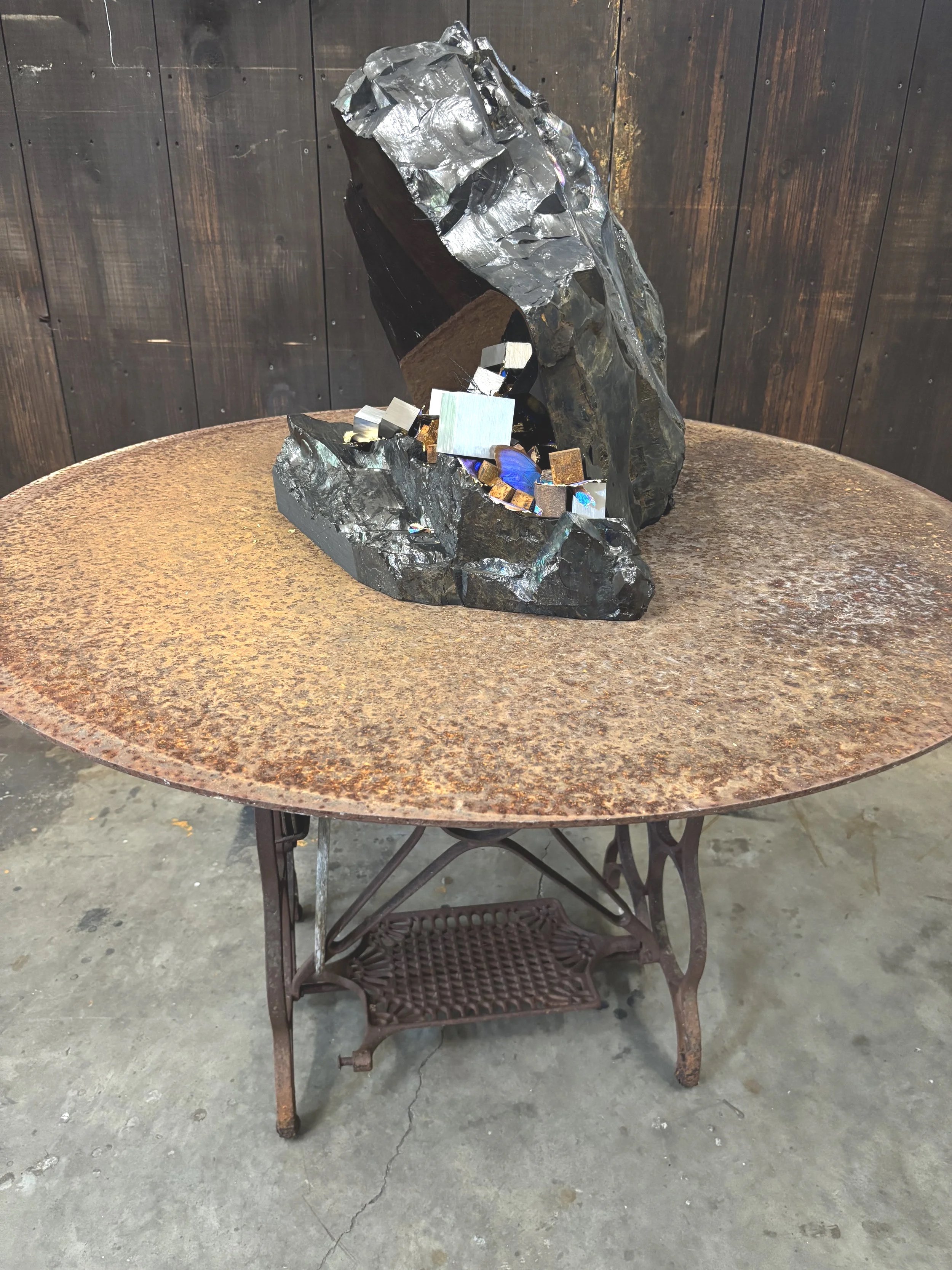 "Carbon Mirror On Disc", 2025, 46"x42"x42", anthracite, steel, Stainless steel, gold leafed wigs of Moroho aega and Morpho anaxibia