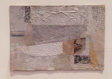 Collage of various pieces of white, grey, yellow textured paper