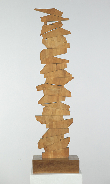 Vertical wood sculpture with asymmetrical pieces jutting out