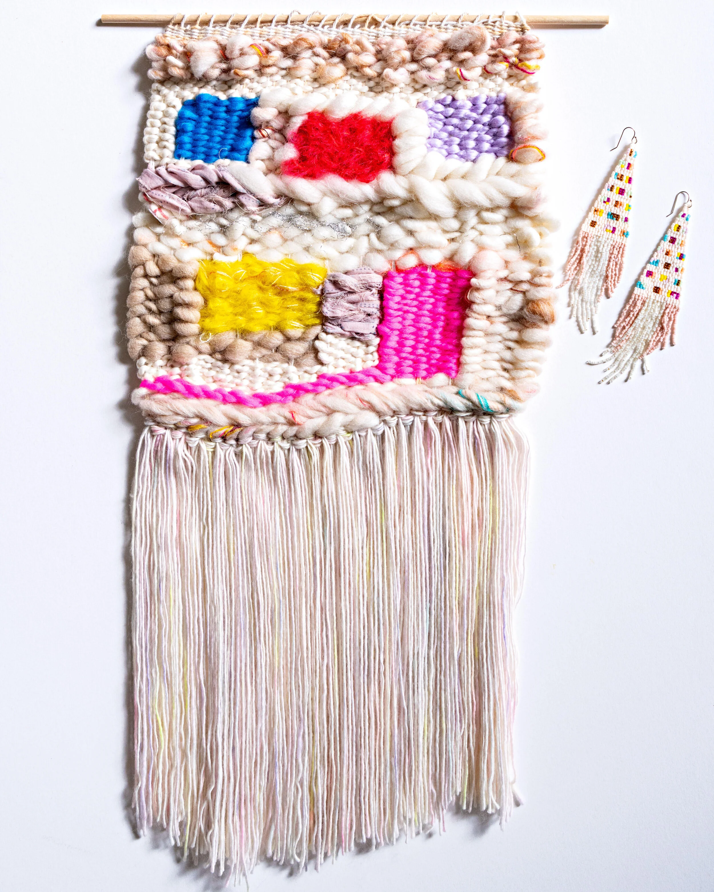 Off-white and beige woven tapestry with red, blue, purple, yellow and pink squares made out of wool, mohair, and cotton