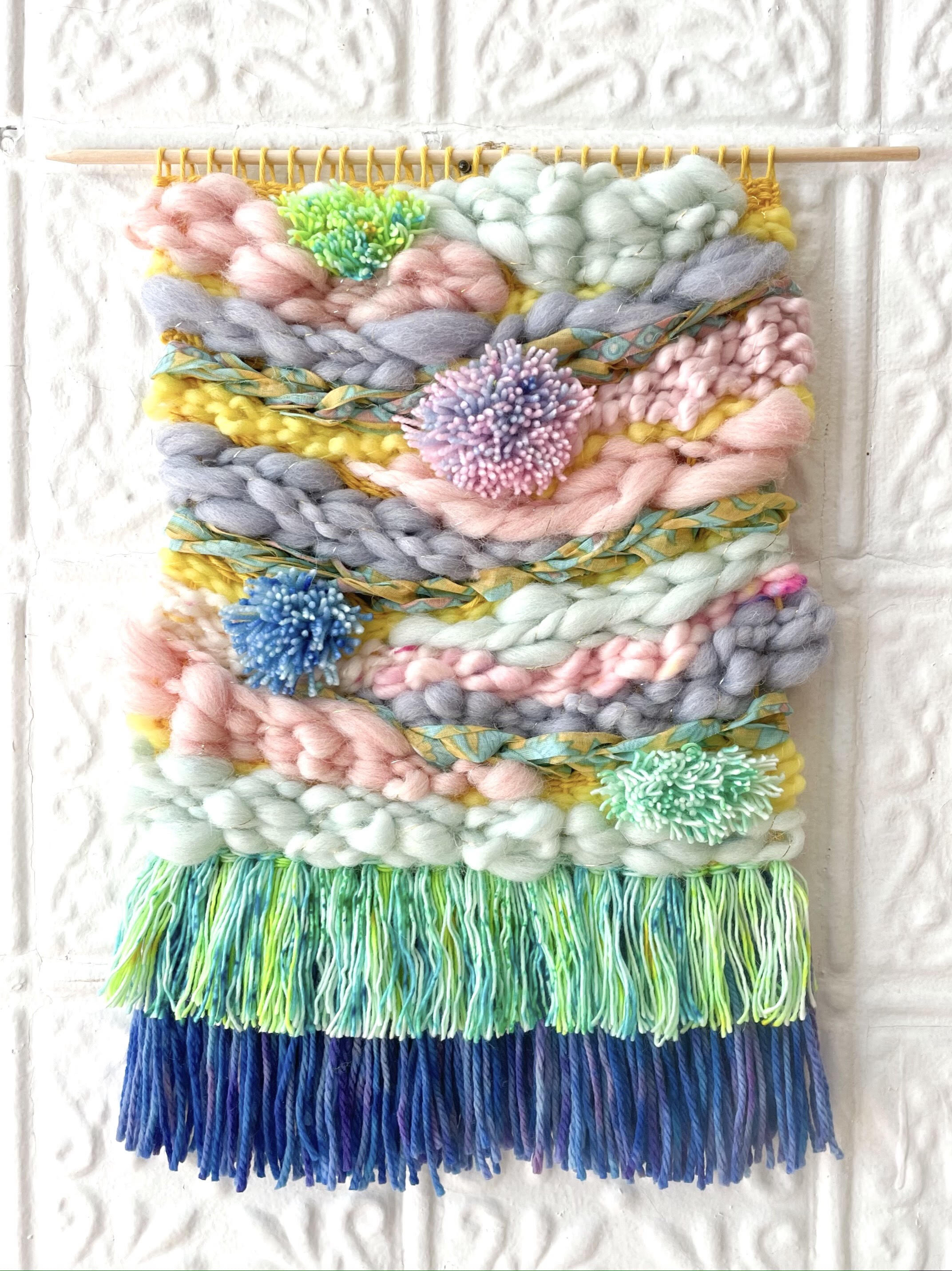 Pink, grey, yellow, green, blue colored woven tapestry made out of wool and cotton