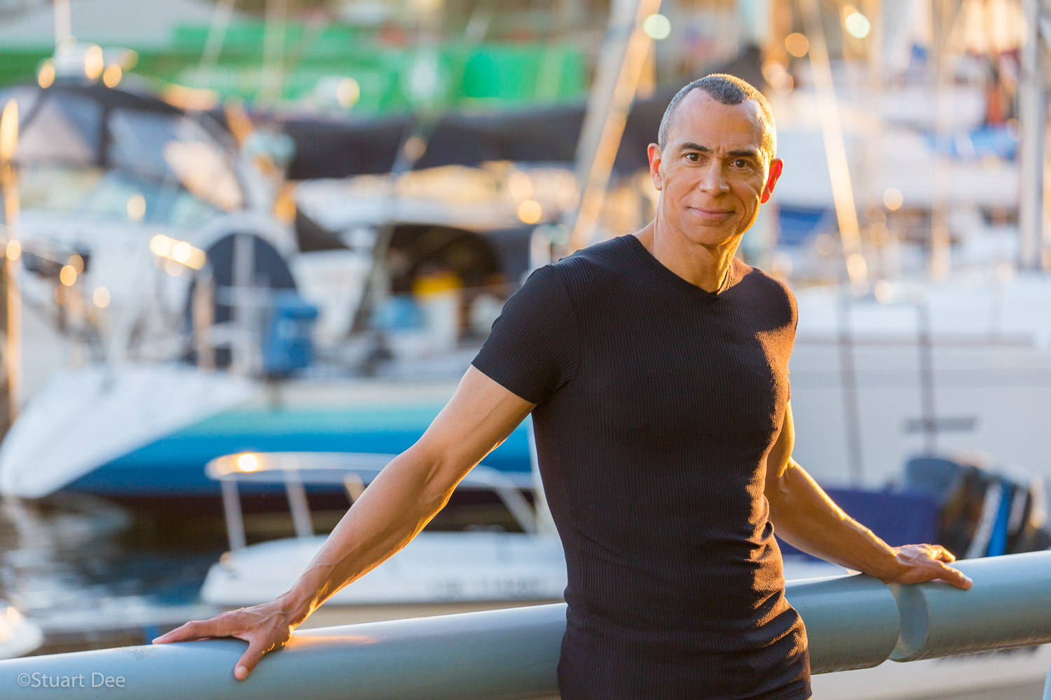 Man outdoors, by a marina with boats