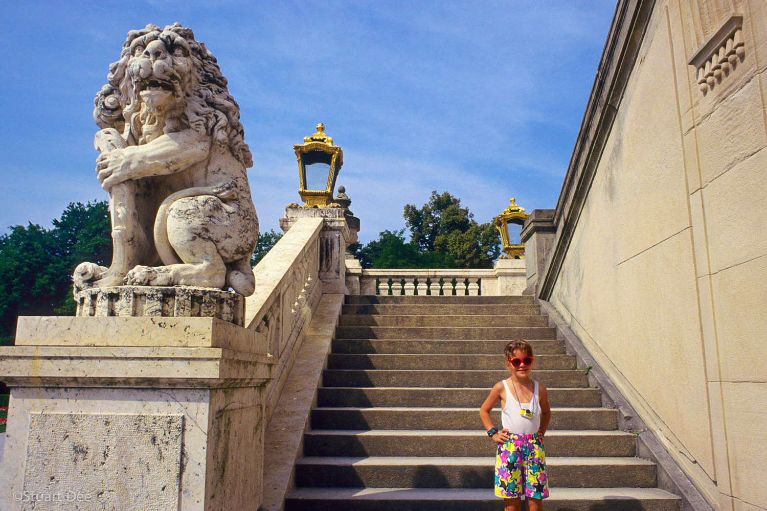A young tourist poses in front of the steps of Nymphenburg Palace, Munich, Germany.
