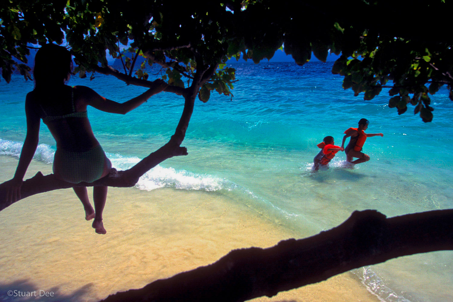  Woman watching two children playing on a beach, Entalula Island, El Nido, Palawan, Philippines 