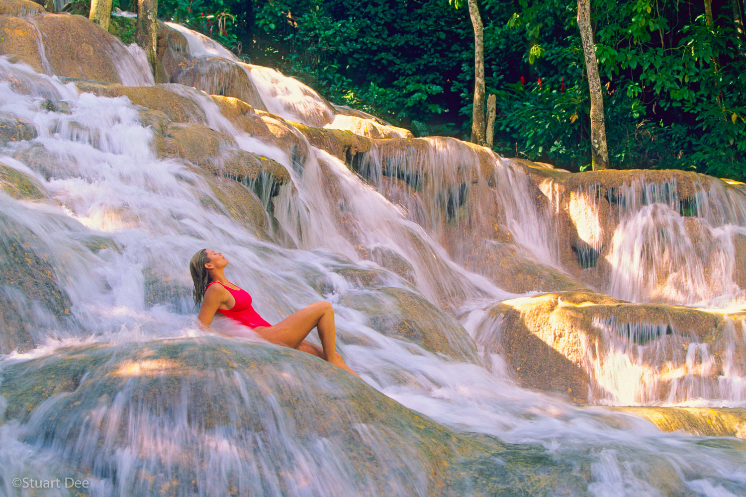 Woman relaxing at falls, Dunn's River Falls, Ocho Rios, Jamaica. Dunn's River Falls is the most visited tourist site in the Carribbean. R