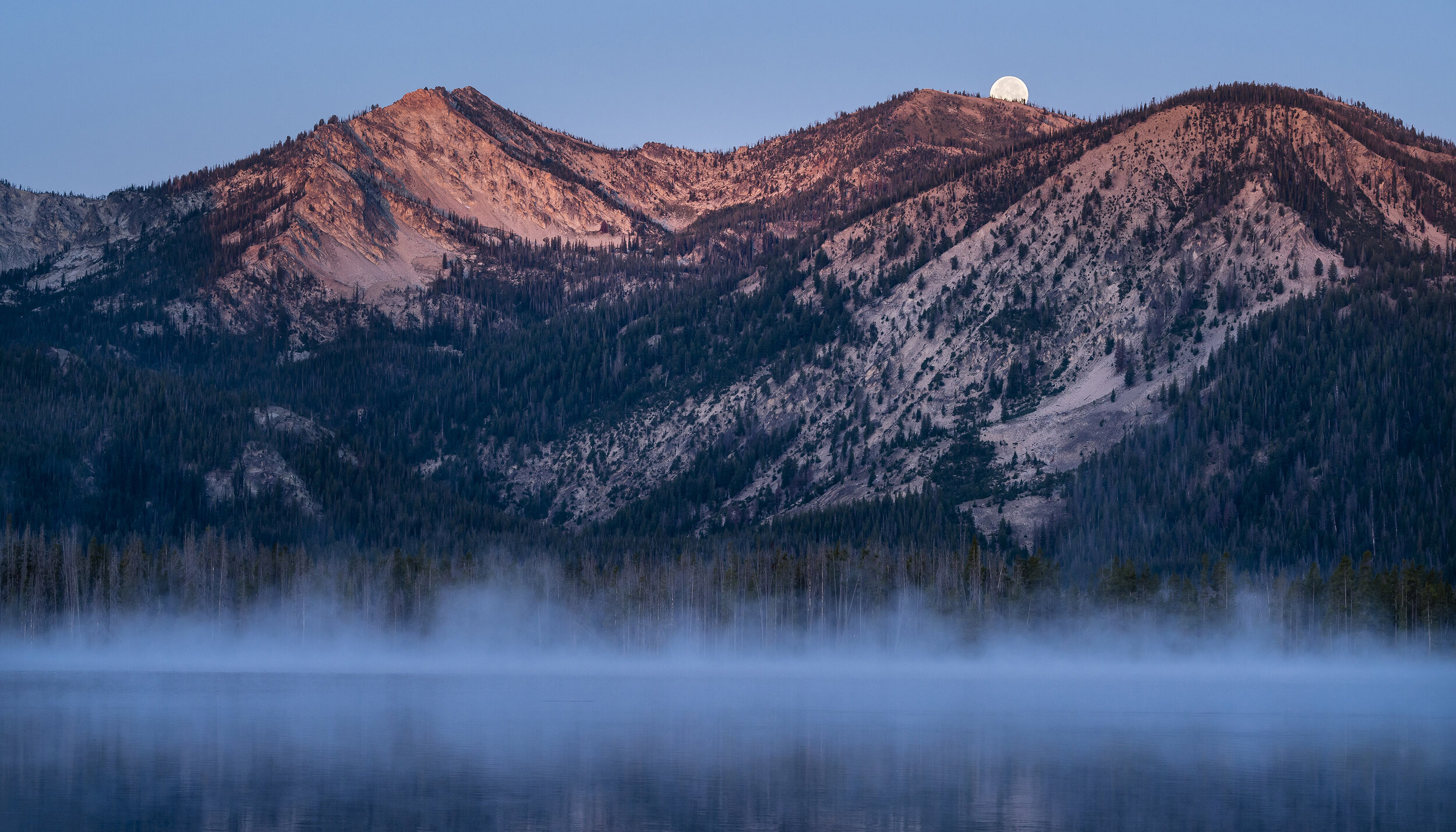  Landscape: The full moon setting over Stanley Lake and the Sawtooth Mountains at sunrise, Sawtooth Mountains, Idaho 