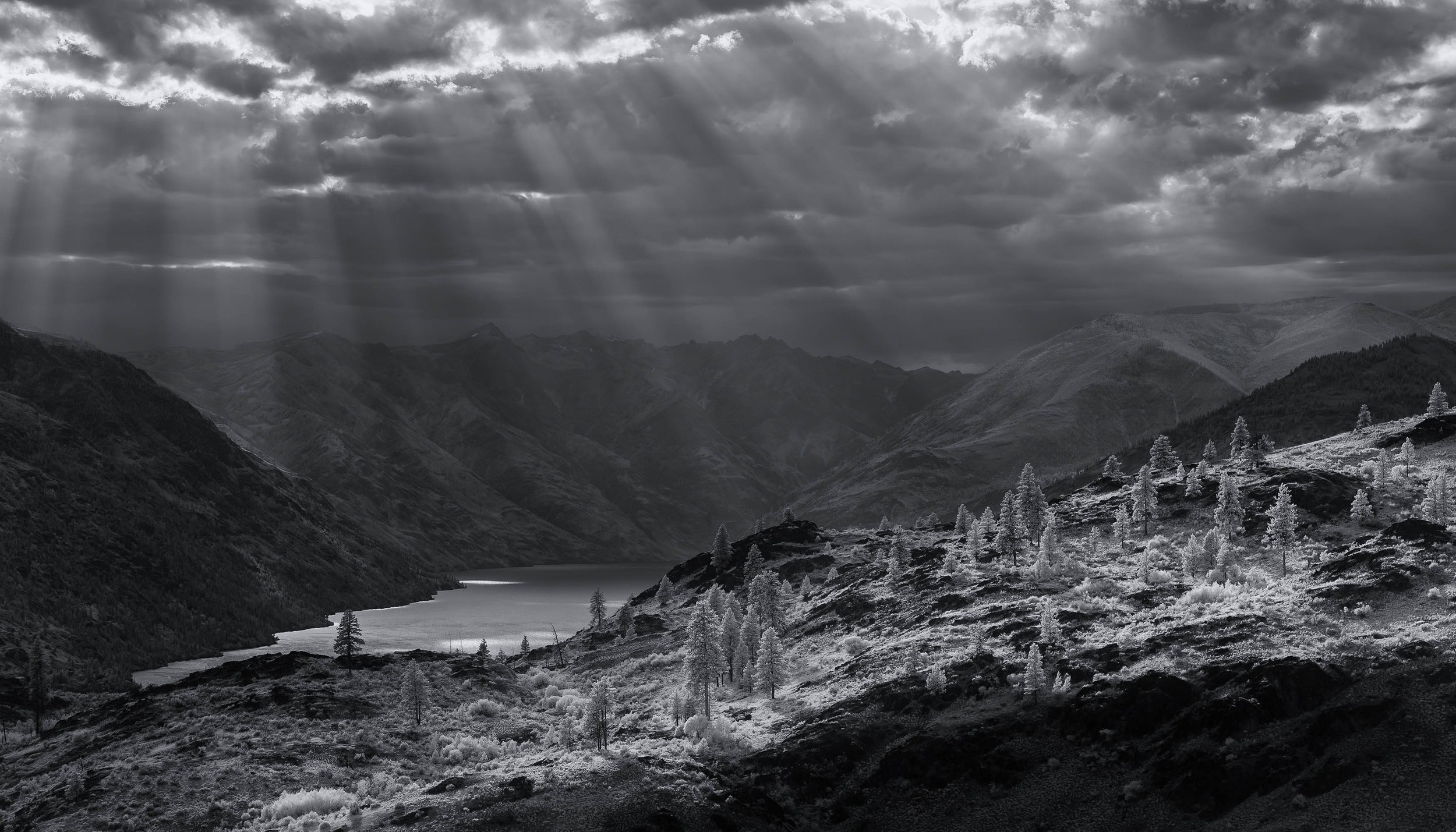  Landscape: Shafts of light break through heavy clouds over Lake Chelan in summer, Wenatchee National Forest, Washington 