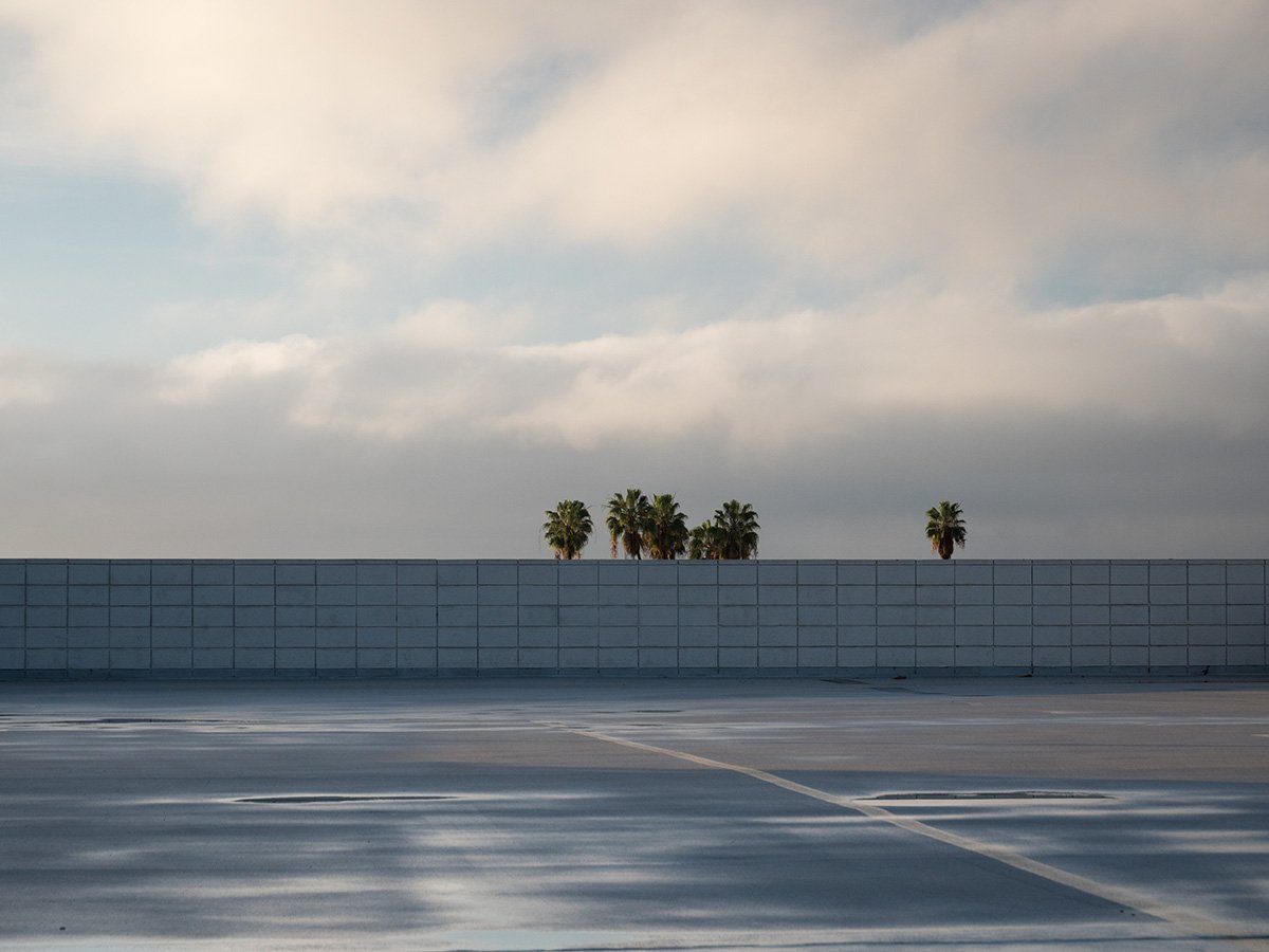  Deck Studies explores the elevated, empty top decks of urban parking structures across Pasadena, California. Positioned above the street level, these utilitarian concrete spaces serve as quiet vantage points and visual sanctuaries—letting the adjace