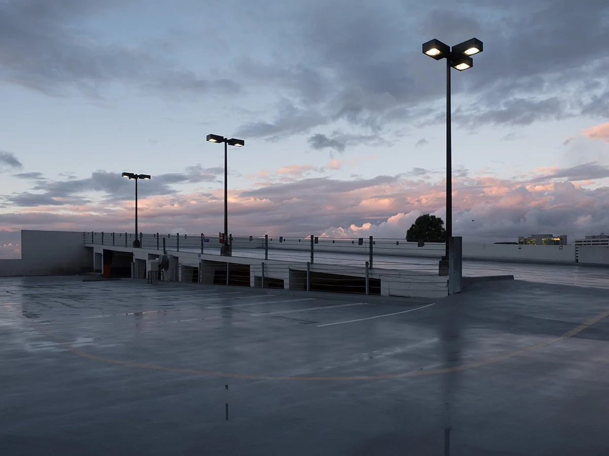  Deck Studies explores the elevated, empty top decks of urban parking structures across Pasadena, California. Positioned above the street level, these utilitarian concrete spaces serve as quiet vantage points and visual sanctuaries—letting the adjace