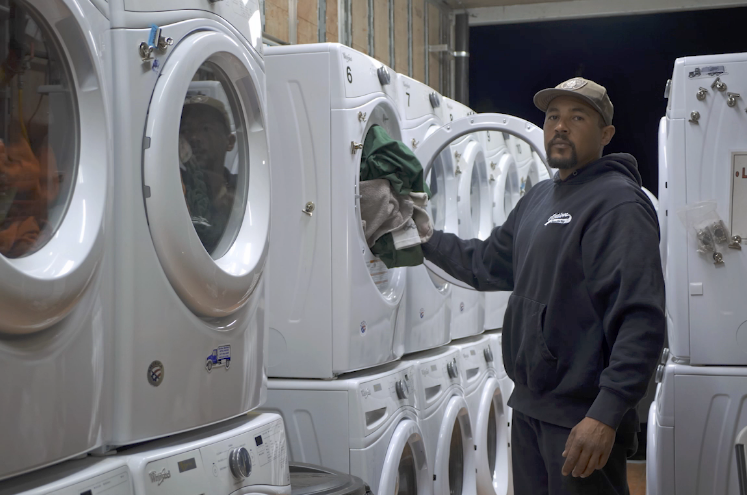    Chris Edwards of Action Sanitary cleans firefighters’ laundry at base camp in Santa Rosa, California, on Tuesday, Oct. 29, 2019. 