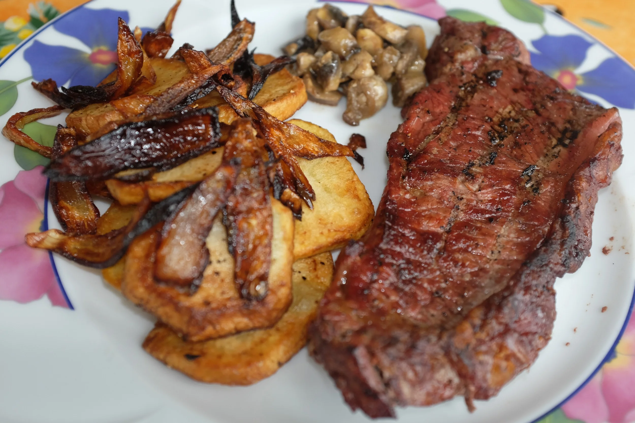 Charcoal fried steak with fried potatoes and onions
